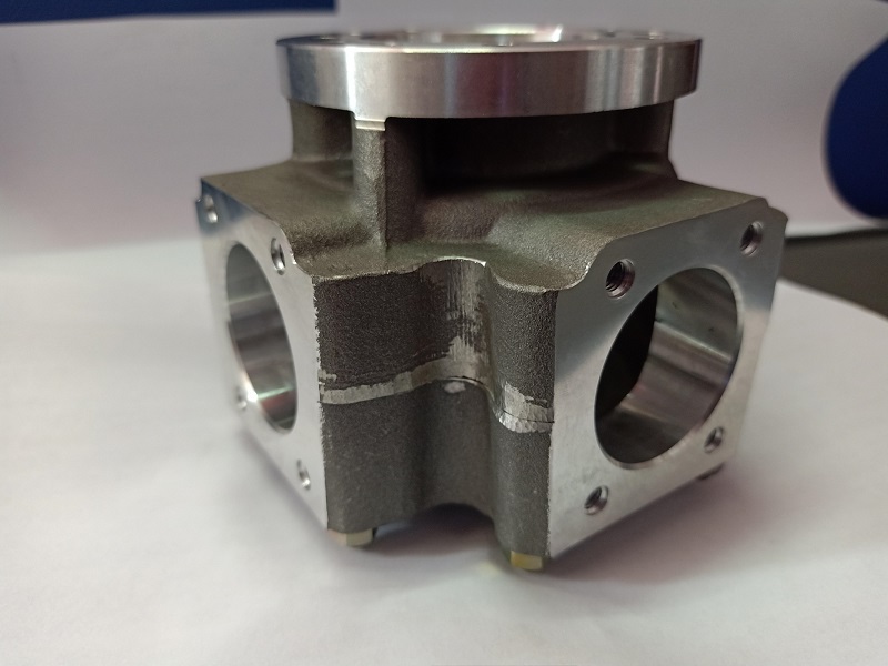 Steel manifold housing with flanged top and side ports